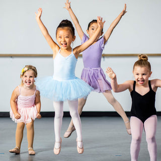 Excited children in colorful dance costumes, joyfully performing a group ballet routine